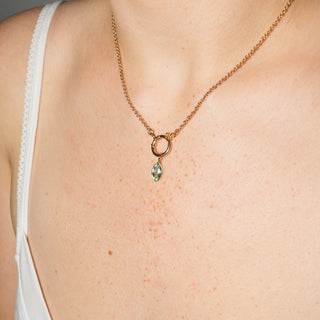 Necklace with a pendant on a person wearing a white top